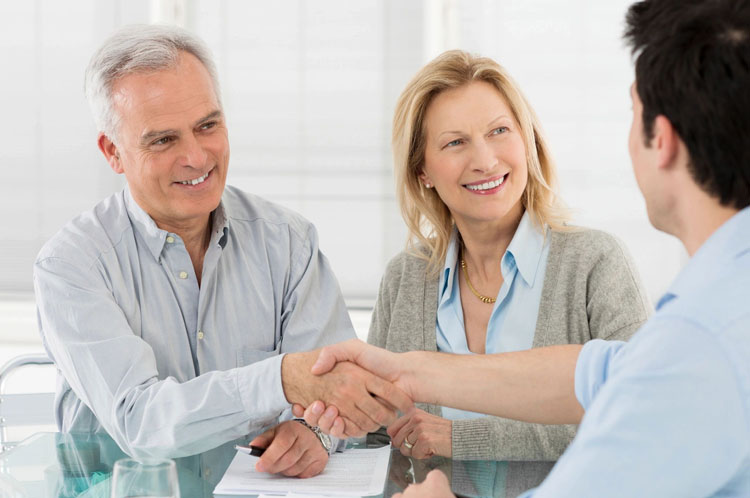 fm=f283 A man and woman shaking hands over a table.