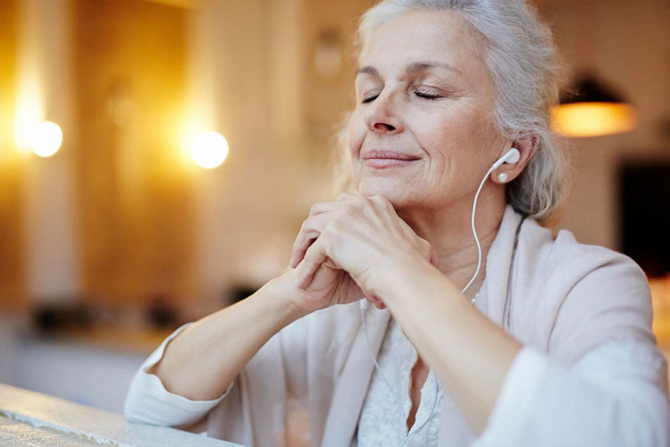 fm=flbwOz44 A woman with her eyes closed listening to music.